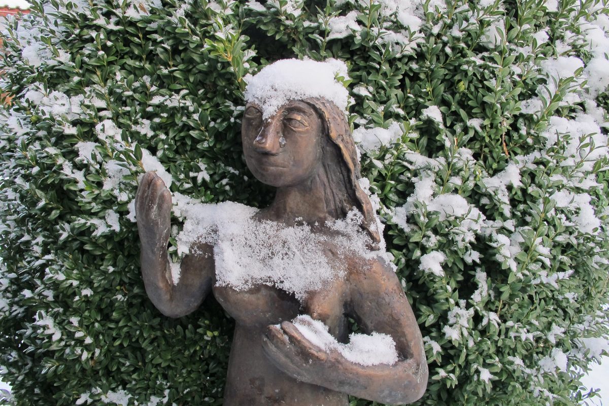 Snow-covered statue in a garden on the Fraueninsel